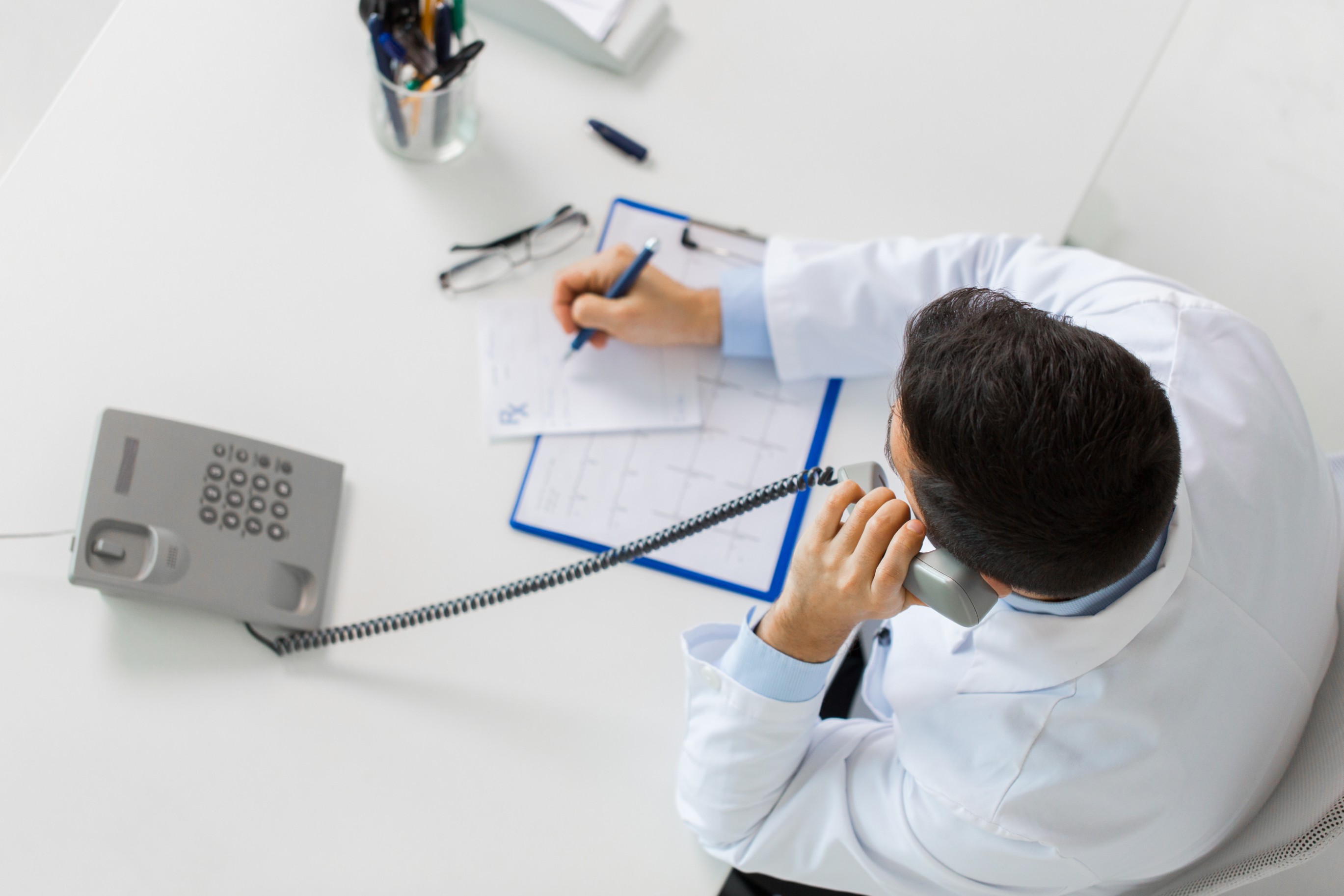 doctor-with-prescription-calling-on-phone-PK33AC4