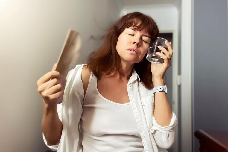 a-woman-cooling-down-with-a-fan-and-glass-of-water-2021-08-30-06-55-06-utc-min (1)