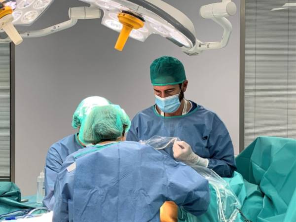 Los doctores Espiñeira (de espaldas) y Contreras realizando una biopsia de ganglio centinela en quirófano.