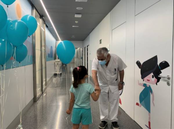 Una paciente de Urgencias pediátricas recibe sus regalos junto al jefe de Pediatría , Javier Baena.
