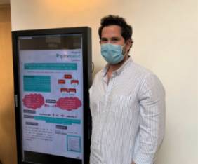 José Viso, supervisor de Enfermería del Área de Hospitalización, junto a su poster.