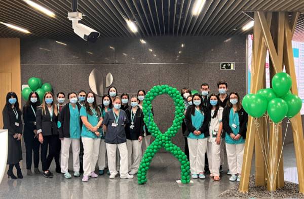 Profesionales del Hospital Quirónsalud Córdoba junto a los globos y lazo de color verde, que simboliza la lucha contra el cáncer.