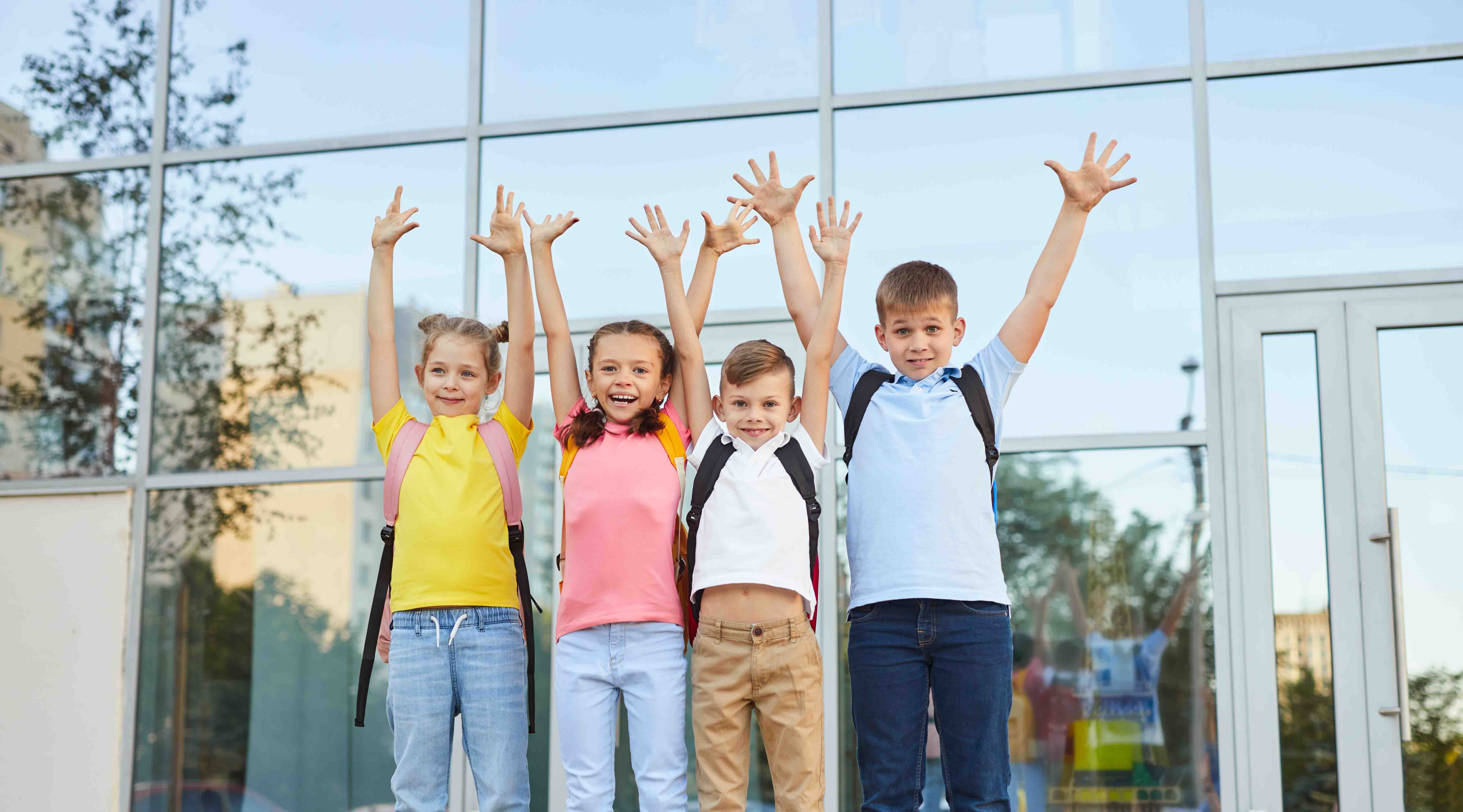 enthusiastic-children-with-raised-arms-near-school-2026-01-09-06-51-31-utc