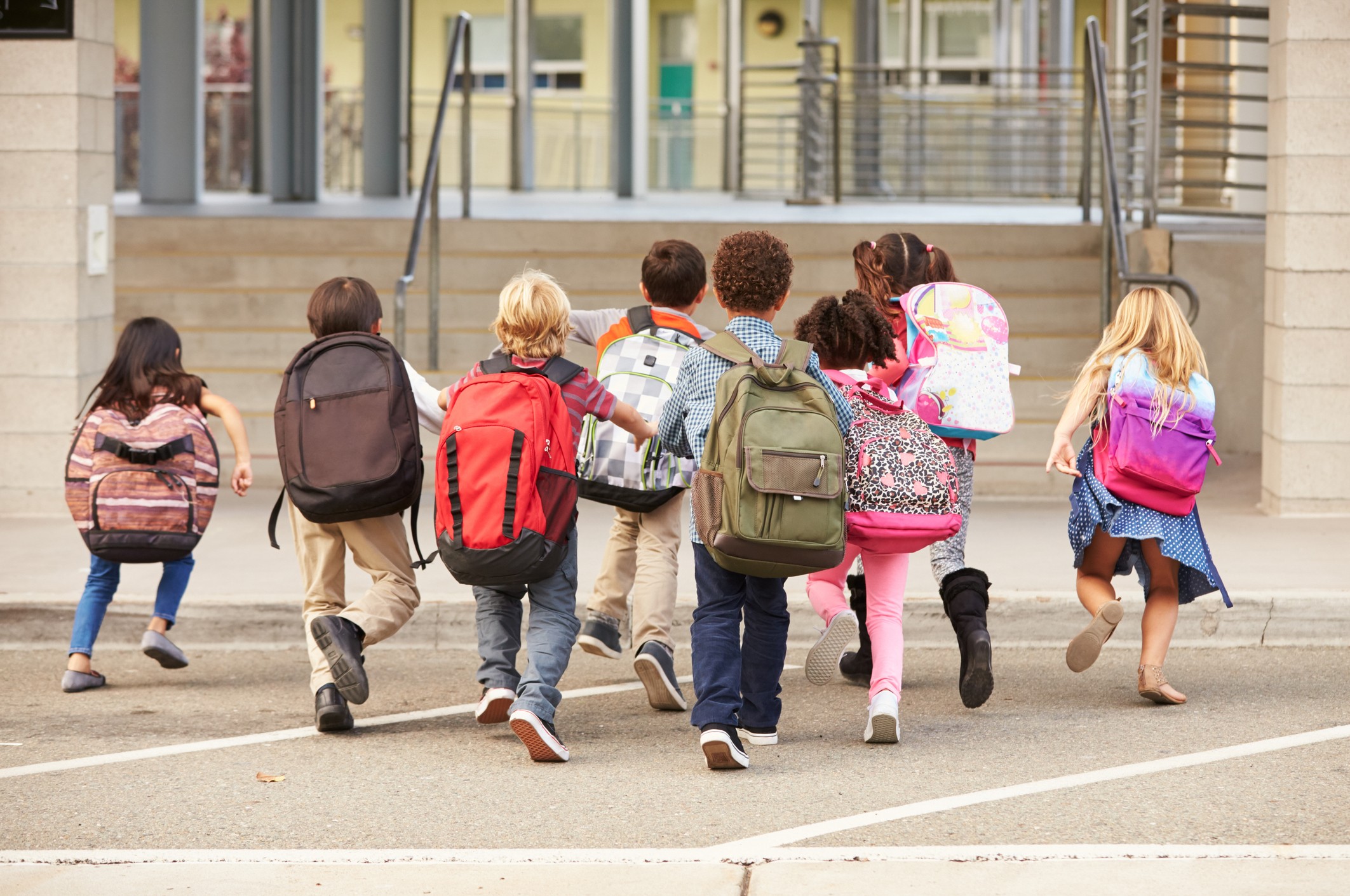 niños en cole con mochilas