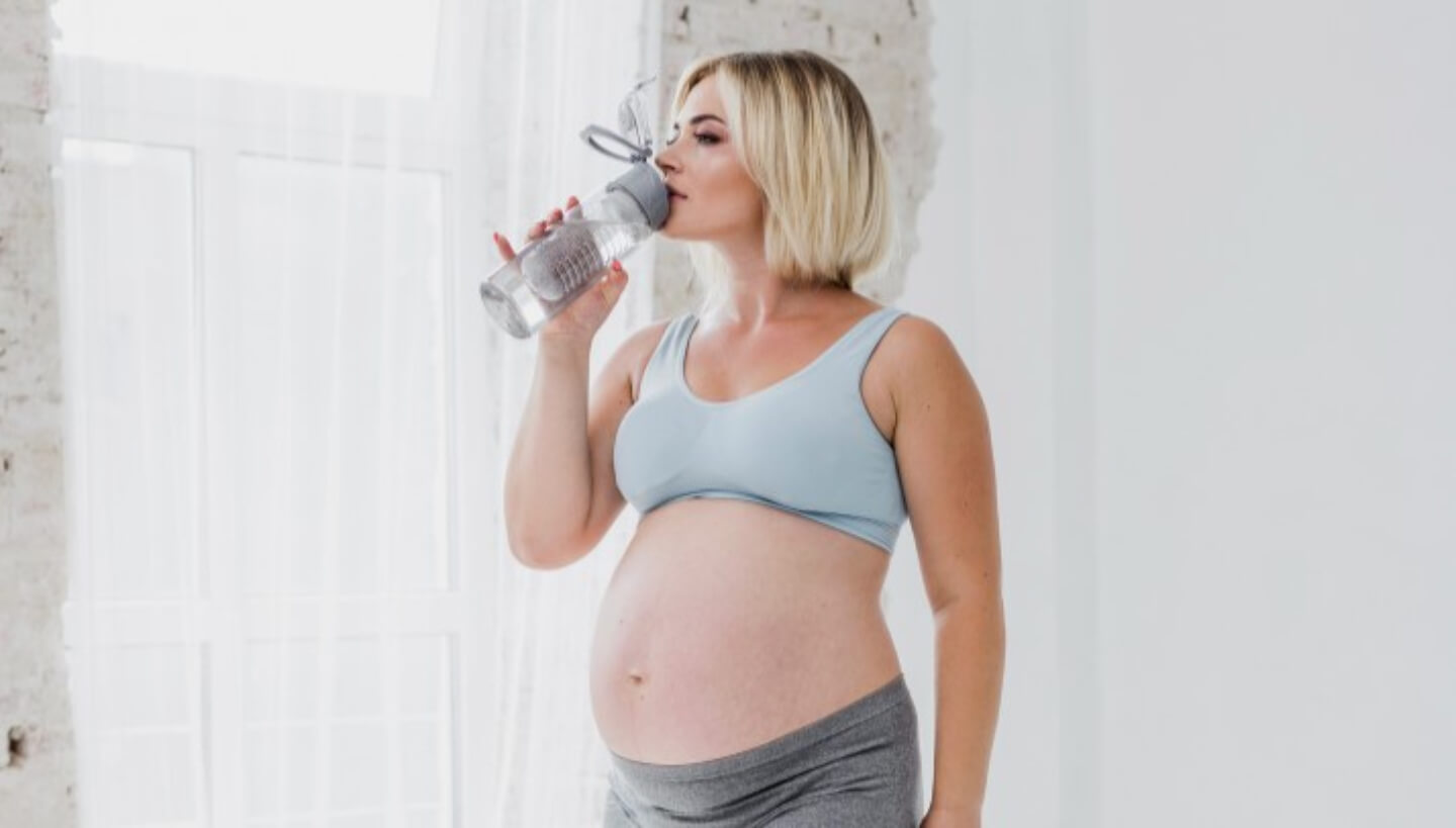 Mujer embarazada bebiendo agua
