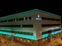 Fachada iluminada verde agua ASACO