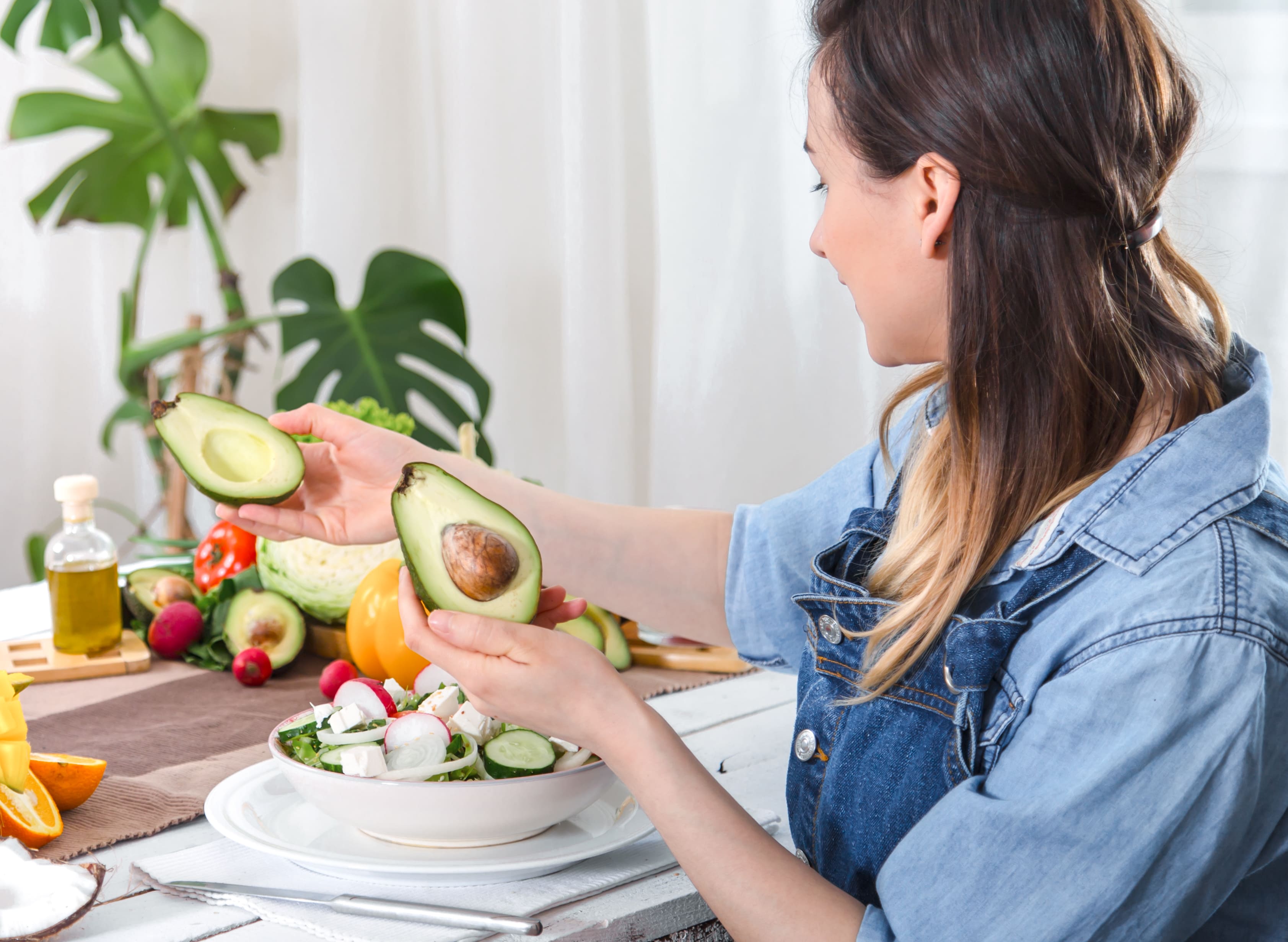 young-happy-woman-looking-avocado-dinner-table (1)